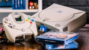 A close-up of the Sega Dreamcast console and controller, with the "Space Channel 5" and "Sonic Adventure" game discs and a Sonic figure placed next to it, showcasing the retro charm of the classic home game console.
